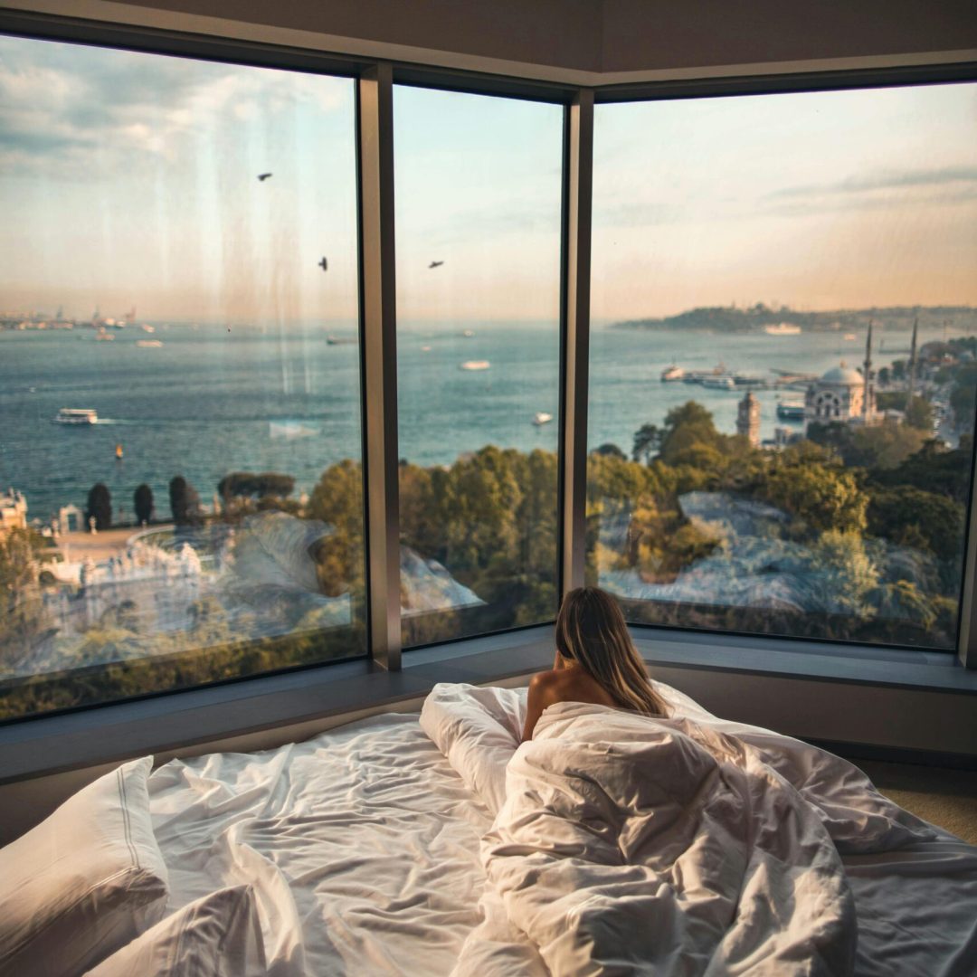 Relaxing in a cozy hotel room with stunning views of the Bosphorus at sunset in Istanbul, Turkey.