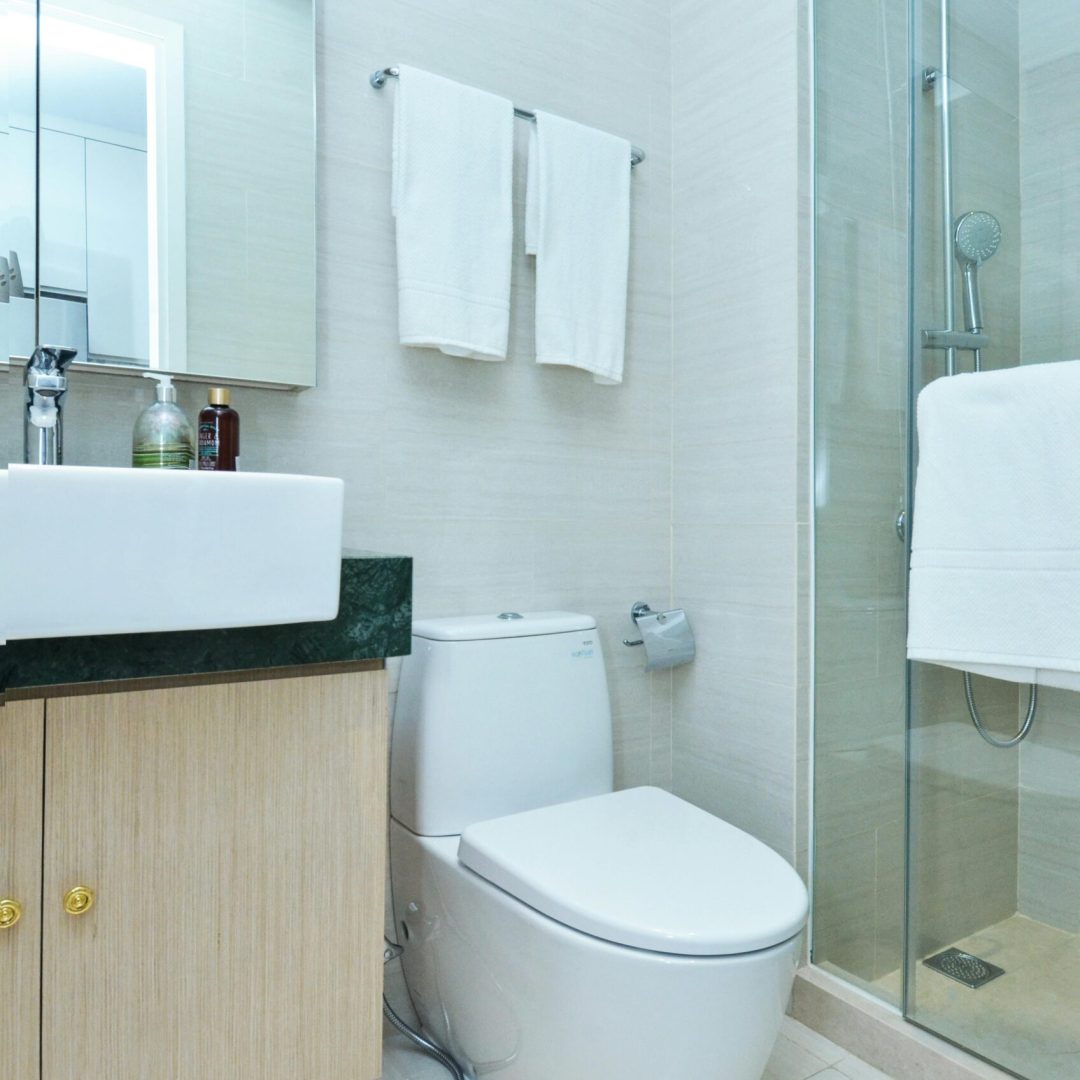 A sleek and clean modern bathroom featuring a shower, toilet, and sink.